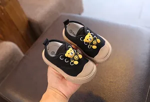 Detailansicht der schwarzen Baby-Stoffschuhe mit süßer gelber Bärenverzierung