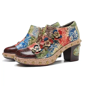 Detail view of vintage floral leather booties with 3D flowers and chunky heels.
