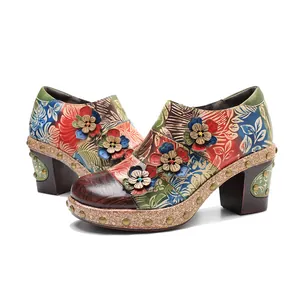 Detail view of vintage genuine leather high heels with colorful floral patterns and 3D flowers