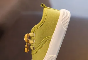 Detailansicht der grünen Kinder-Stoffschuhe mit süßer Cartoon-Bären-Dekoration