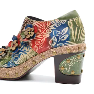 Detail of retro floral embossed leather pump with 3D flower accents and chunky high heel