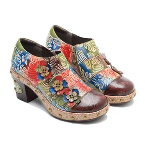 Close-up detail of handmade vintage floral genuine leather shoes with 3D flower accents.