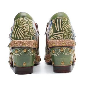 Detailed rear view of vintage green leather block heels with floral pattern and studs.
