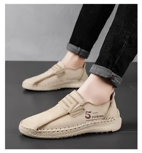Macro detail van beige handgemaakte heren loafers van leer met 5 sport power logo.
