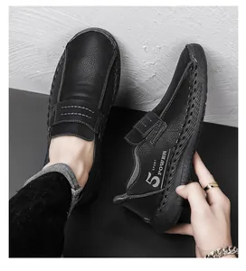 Macro-detail van zwarte leren loafers met handgemaakte stiksels en zij-logo tekst