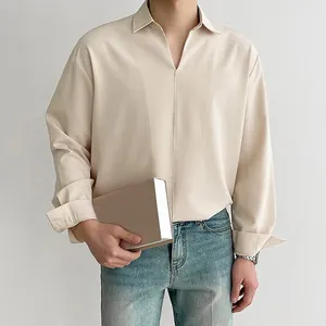 Detail shot of men's loose V-neck long sleeve shirt in beige with smooth drape
