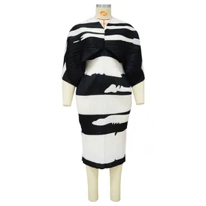 Detalle de vestido plisado de rayas blancas y negras con mangas murciélago y cuello en V
