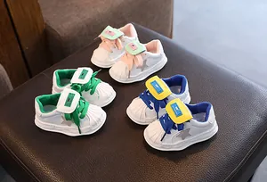 Macro view of colorful children's leather sneakers with star patch and shell-toe design.