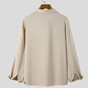 Back view of a men's loose beige long-sleeved shirt with draped fabric and split cuffs