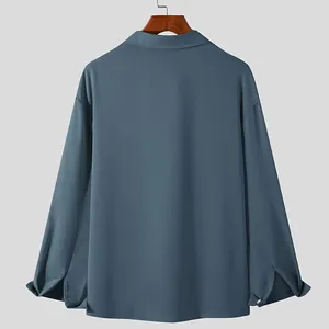 Back view of men's loose long-sleeve casual shirt in dusty blue with drop shoulders