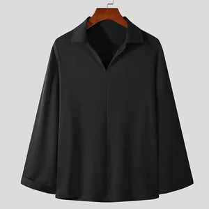 Front view of minimalist black V-neck pullover shirt with long sleeves on wooden hanger