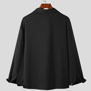 Back view of black long-sleeved loose shirt with smooth draping fabric texture detail
