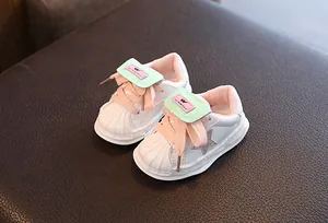 Detailed macro view of white leather sneakers for kids with shell toe and star patch