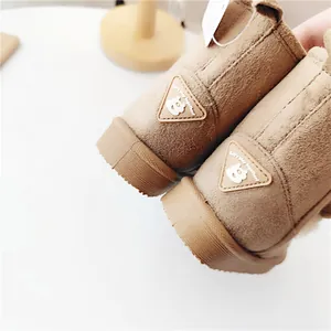Detailansicht brauner Wildleder-Schneestiefel für Kinder mit niedlichem Bären-Patch