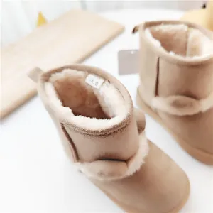 Nahaufnahme warmer Kinder-Schneestiefel mit süßen Bärenohren und dickem Kunstfellfutter