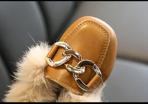 Detailansicht der braunen Mädchen-Loafer mit Metallkette und weichem Pelzbesatz