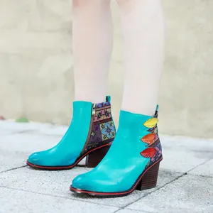 Detalle de botines artesanales de cuero turquesa con tacón de bloque y adornos de hojas