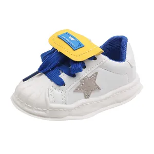 Stylish kids white shell toe sneakers with blue laces and gray star detail in leather