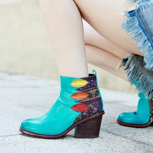 Vista detallada de botines de cuero turquesa con bordados étnicos de colores.