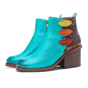 Detalle de botines de cuero vintage hechos a mano con adornos de hojas de colores.