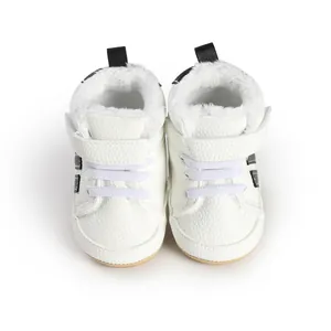 Nahaufnahme weißer Baby-Lauflernschuhe mit warmem Kunstfellfutter und Klettverschluss.