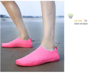 Primo piano di scarpe da scoglio rosa brillante, leggere e antiscivolo sulla spiaggia