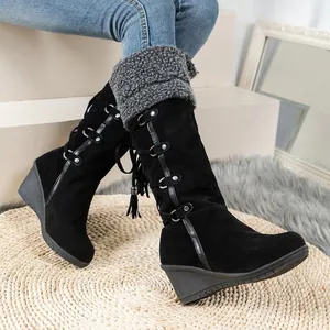 Stylish black suede wedge knee-high boots featuring fringe details and warm shearling trim