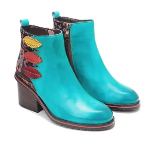Vista detallada de botines de cuero turquesa hechos a mano con motivos bohemios.