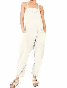 Ganzkörperansicht eines lockeren cremefarbenen Overalls mit großen Taschen und dünnen Trägern.