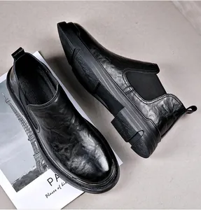Close-up van zwarte leren heren Chelsea boots die de premium textuur en instapstijl tonen