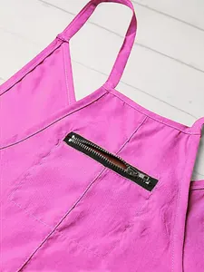Nahaufnahme eines pinkfarbenen Overalls mit Brusttasche und schwarzem Reißverschluss.