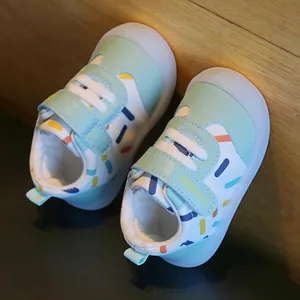 Close-up of mint green baby walking shoes with colorful sprinkle patterns and soft soles