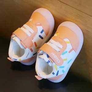 Close-up of baby walking shoes featuring colorful sprinkles pattern and velcro strap