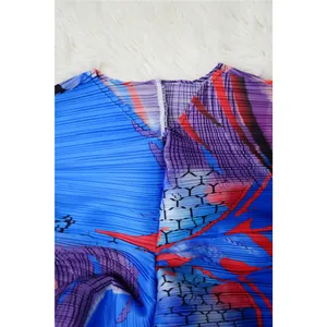 Vista de cerca del cuello en V y la textura de la tela plisada del vestido estampado vibrante