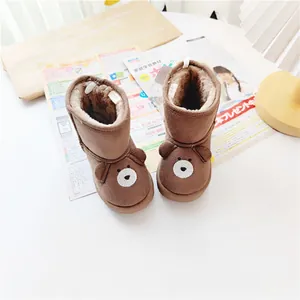 Close-up of brown cartoon bear toddler snow boots with warm faux fur lining.
