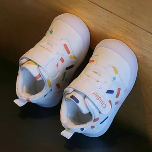Detail of breathable baby walking shoes with colorful dash patterns and velcro straps