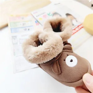 Close-up of cozy brown cartoon bear baby snow boots with thick warm faux fur lining.