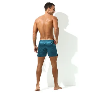 Detail view showing the back of teal satin men's lounge shorts with an elastic waistband