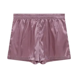 Macro view showing the glossy texture of men's satin lounge shorts in dusty rose color.