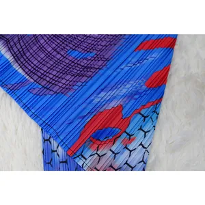Detalle de primer plano de la tela plisada en un vestido colorido con mangas murciélago