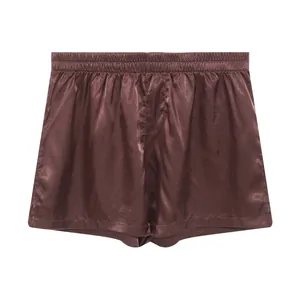 High-quality detail view of smooth brown satin men's lounge boxers with elastic waist.