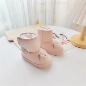 Close-up of pink children's snow boots with cute plush puppy design and warm lining