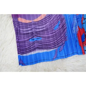 Primer plano de tela plisada con estampado gráfico en un vestido con manga de murciélago