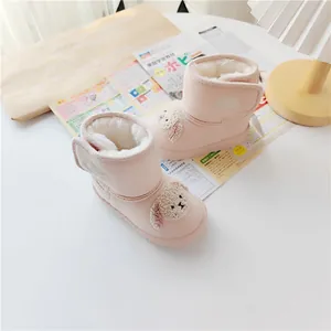Close-up of pink toddler snow boots with plush lining and cute cartoon dog design.