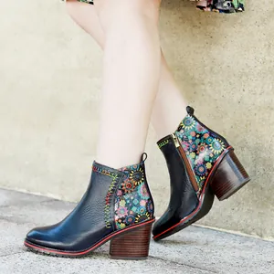 Detail shot of vintage leather ankle boots with floral patchwork and chunky heel