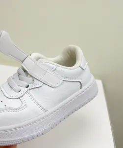 Close-up of white toddler board shoe showing leather texture and velcro strap detail