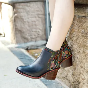 Detail of vintage patchwork leather ankle boots with floral patterns and block heel