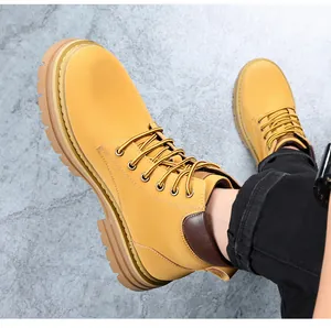 Dichtbij zicht op klassieke gele leren heren werkschoenen op een stenen ondergrond