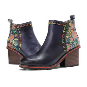 Detailed view of vintage dark blue leather ankle boots with floral patterns and colorful stitching.
