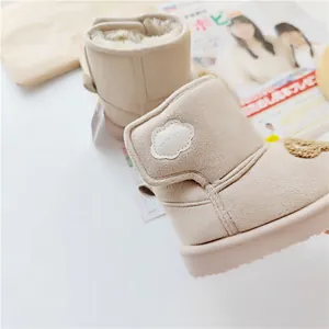 Close-up of beige children's snow boots with soft fleece lining and cloud detail